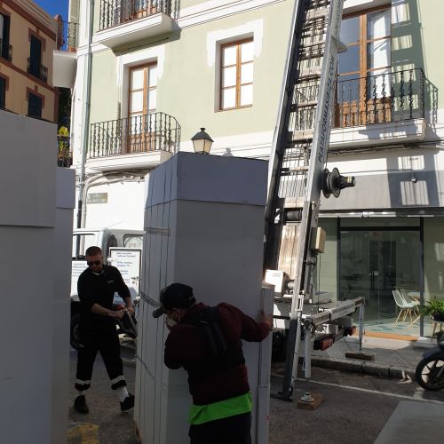 Operarios moviendo los muebles embalados